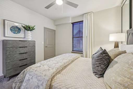 bedroom with large bed and a dresser at Vine + Vail Townhomes and Apartments, Grapevine, TX 76051