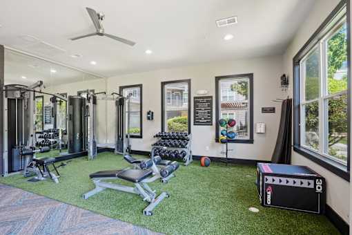 A gym with a variety of equipment including weights and a treadmill at Highline Urban Lofts Apartments, Texas