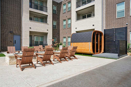A modern outdoor seating area with chairs and a table is set up in front of a building.