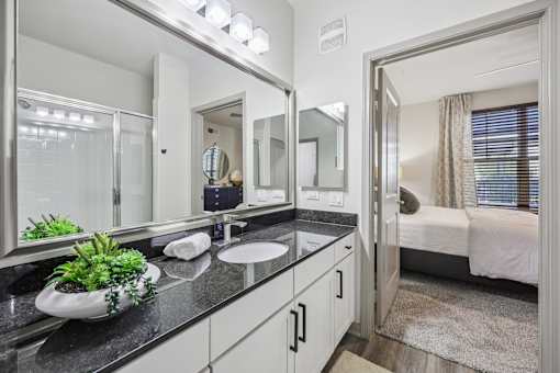 bathroom with a large mirror at Vine + Vail Townhomes and Apartments, Grapevine, TX