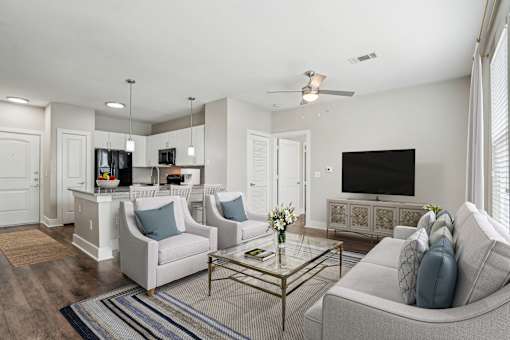 A living room with a grey couch, a coffee table, and a television at Highline Urban Lofts Apartments, Cypress, TX, 77429