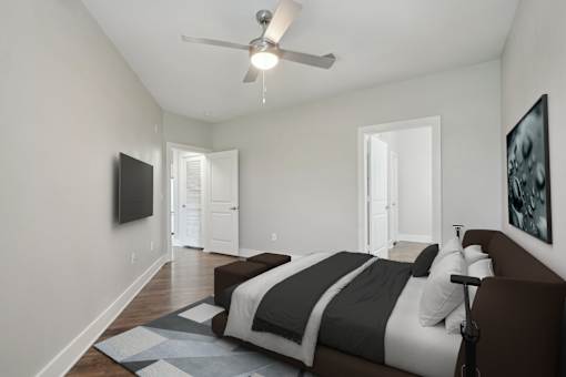 A bedroom with a bed, a ceiling fan, and a television at Highline Urban Lofts Apartments, Texas
