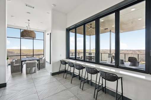A room with a table and chairs with a view of the outside.