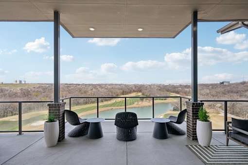 A patio with a view of a golf course and a lake.