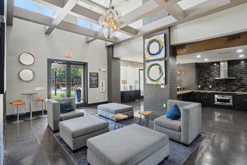 A modern living room with grey couches and a chandelier at Highline Urban Lofts Apartments, Cypress 77429