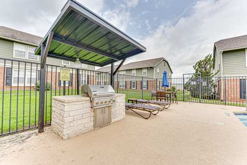Outdoor grilling station with seating area at Arbors Of Corsicana Apartments, Corsicana, Texas