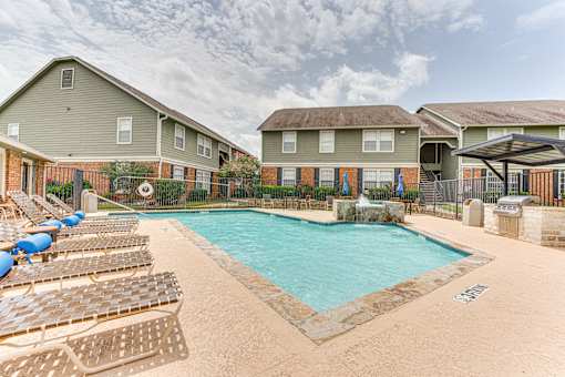 Swimming pool with lounge chairs and water feature at Arbors Of Corsicana Apartments, Corsicana, 75110