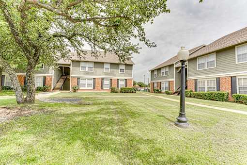 Two story apartment buildings with courtyard at Arbors Of Corsicana Apartments, Corsicana