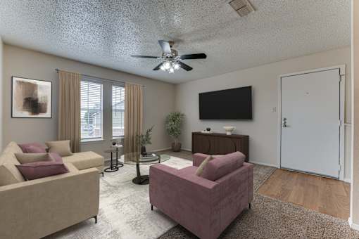 Living room with ceiling fan and wall mounted tv at Arbors Of Corsicana Apartments, Corsicana