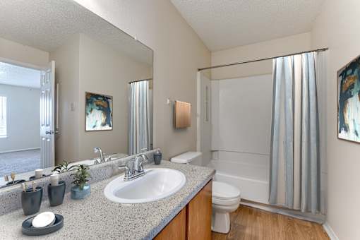 Bathroom with granite countertop and tub shower combo at Arbors Of Corsicana Apartments, Corsicana, TX