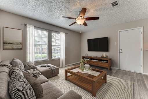 Living room with sectional sofa and entertainment center at Arbors Of Corsicana Apartments, Corsicana, 75110