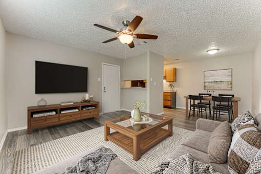 Open living space with wood furniture and ceiling fan at Arbors Of Corsicana Apartments, Corsicana, Texas