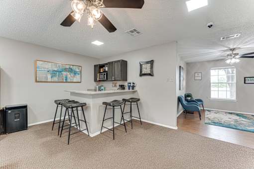Breakfast bar with bar stools and overhead cabinetry at Arbors Of Corsicana Apartments, Texas