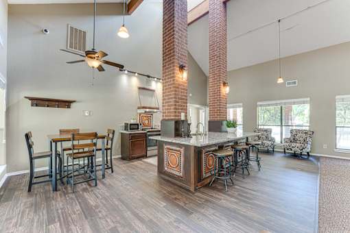 A kitchen with a bar and chairs.