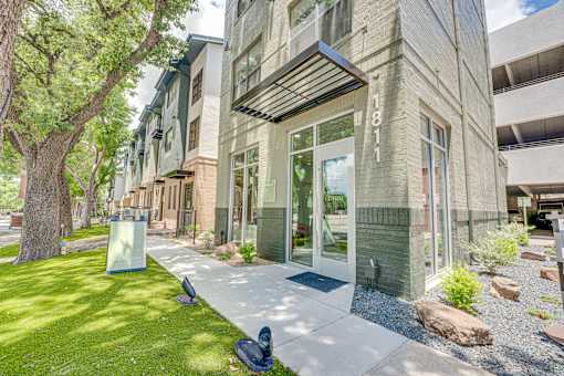 Modern building exterior with glass entry doors at The Barton Apartments, Dallas