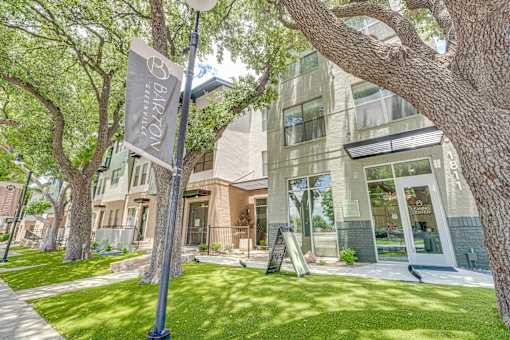 Modern building exterior with landscaped lawn at The Barton Apartments, Texas