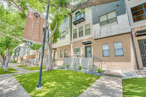 Townhome style building with tree lined sidewalk at The Barton Apartments, Dallas, TX 75206