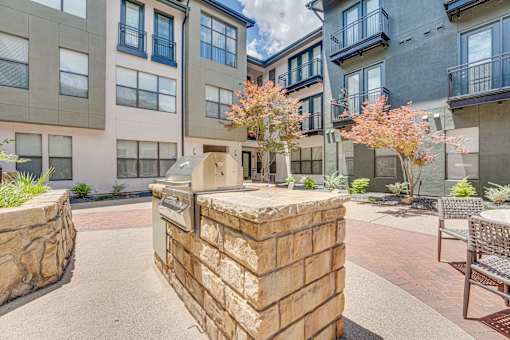 Courtyard with outdoor grills and seating area at The Barton Apartments, Dallas, Texas