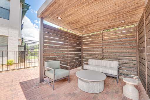 Covered outdoor patio with wood privacy screens at The Barton Apartments, Dallas, Texas