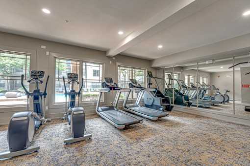 A gym with treadmills, elliptical machines, and stationary bikes.