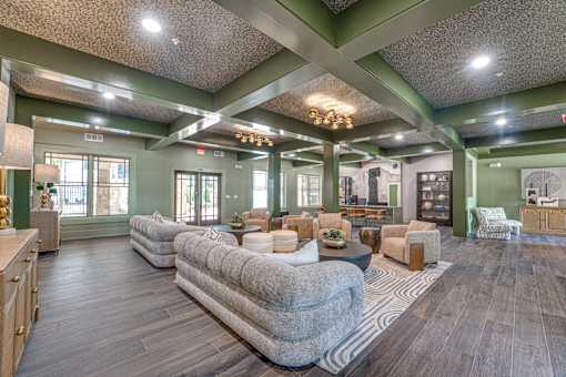 A spacious living room with a grey sofa and wooden floors.