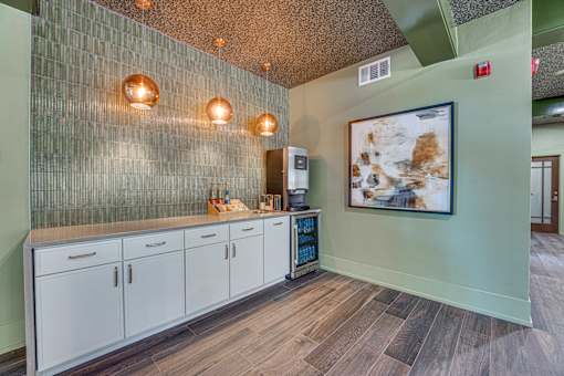 A kitchen with a green wall and wooden floors.