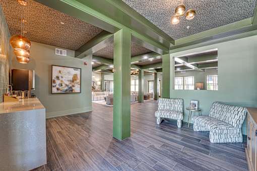 A room with a green wall and a painting hanging on it.