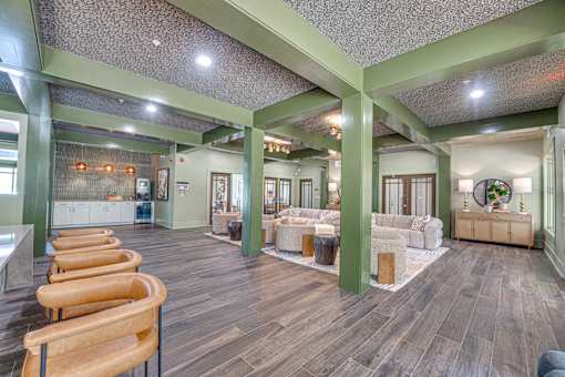 A large room with wooden floors and a long row of chairs.
