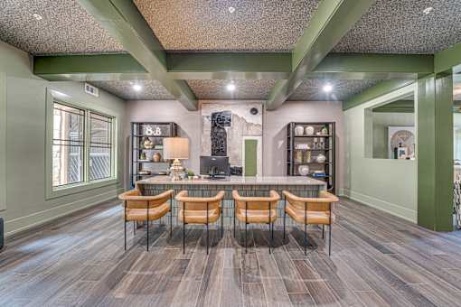 A room with a bar area and chairs.