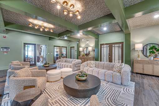 A living room with a large couch, a coffee table, and a rug.