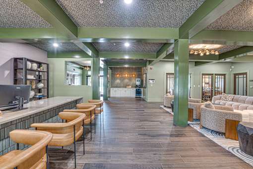 A long hallway with chairs on the left and a couch on the right.