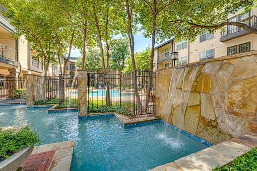A pool surrounded by a fence and trees.