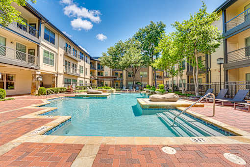 A swimming pool surrounded by apartment buildings.