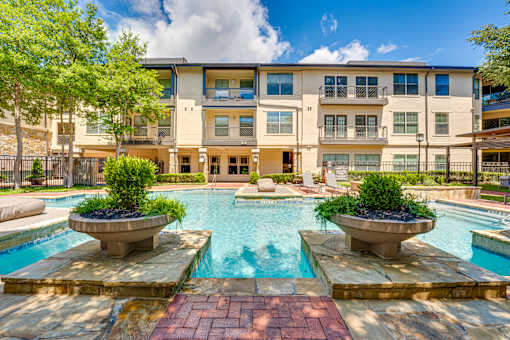 A large apartment complex with a pool in the foreground.
