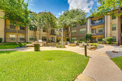 A sunny day at a well-maintained apartment complex with a walking path.