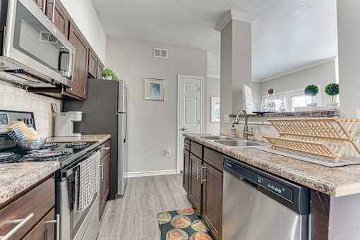A kitchen with a black fridge and a black stove top oven. at The Brazos, Dallas, TX