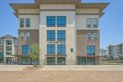 The Carter building has a brick facade and is surrounded by a fence.