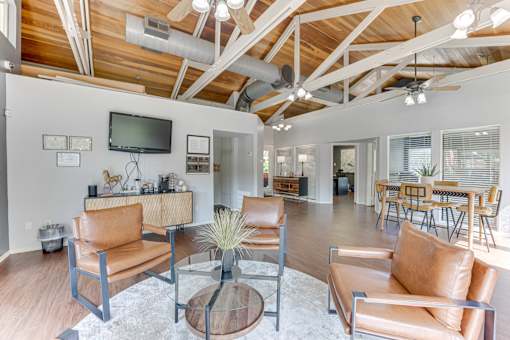 A living room with a brown leather couch and a glass coffee table at Copper Hill Apartments, Bedford, TX