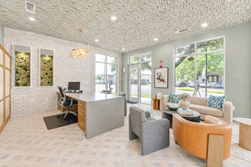 Modern office with lounge seating and glass doors at The Barton Apartments, Texas