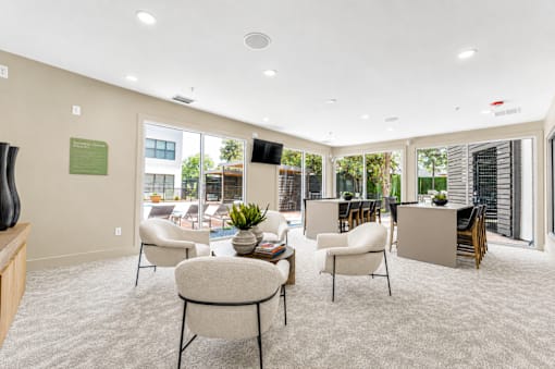 Community clubroom with patio access and seating at The Barton Apartments, Dallas, TX