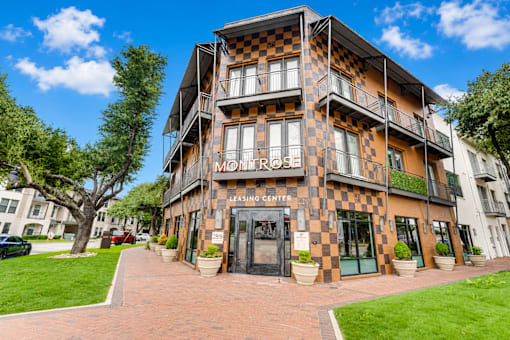 Property entrance with checkerboard facade and balconies at The Montrose Apartments, Dallas, 75204