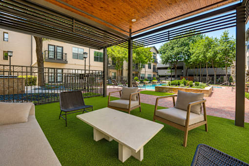 A patio with a table and chairs under a roof.