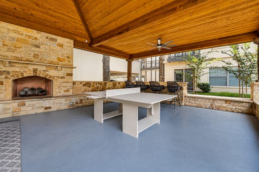 A room with a stone fireplace and a white table.
