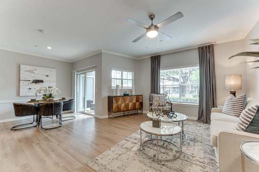 A living room with a white ceiling fan and a coffee table in the middle at Limestone Ranch Apartments, Texas