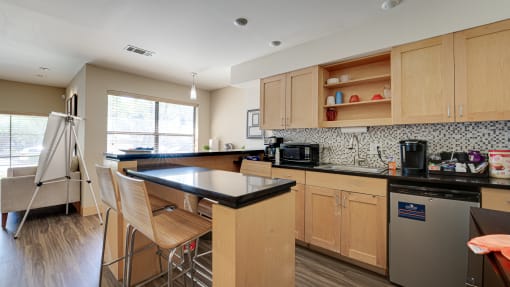 a kitchen with wooden cabinets at The Manhattan Apartments, Dallas, 75252