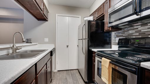a kitchen with a sink and a refrigerator at The Manhattan Apartments, Dallas, Texas