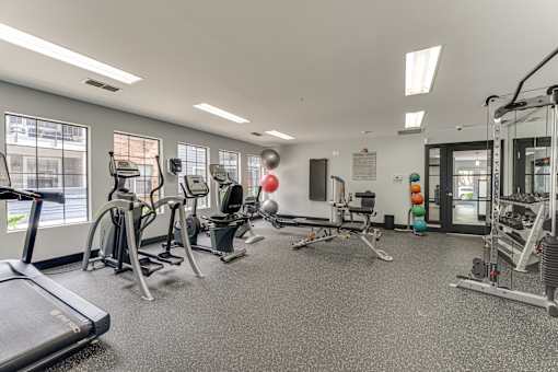 A gym with treadmills, weights, and exercise equipment. at The Manhattan Apartments, Dallas, Texas