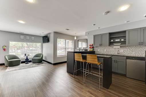 A modern kitchen with a bar stool and a chair. at The Manhattan Apartments, Texas, 75252