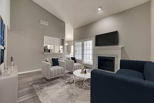 A living room with a fireplace and a television. at The Manhattan Apartments, Dallas, Texas