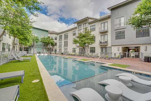 Outdoor swimming pool with sundeck and lounge chairs at The Montrose Apartments, Dallas